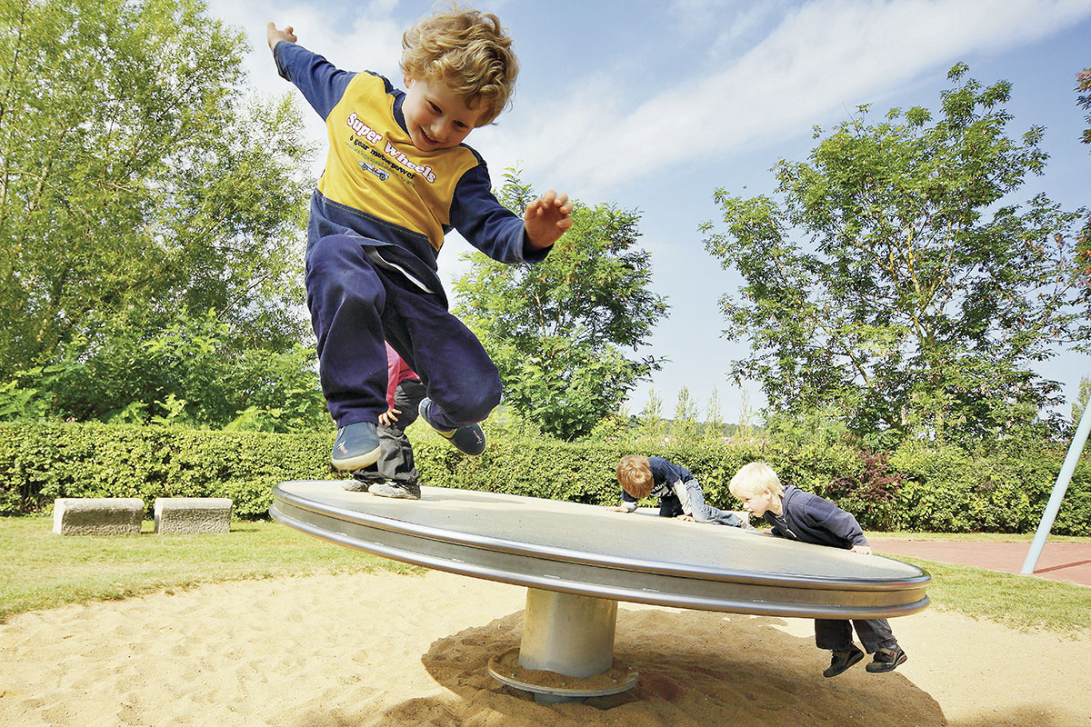Fall protection on the playground - a boy jumping from a balance device on the playground.
